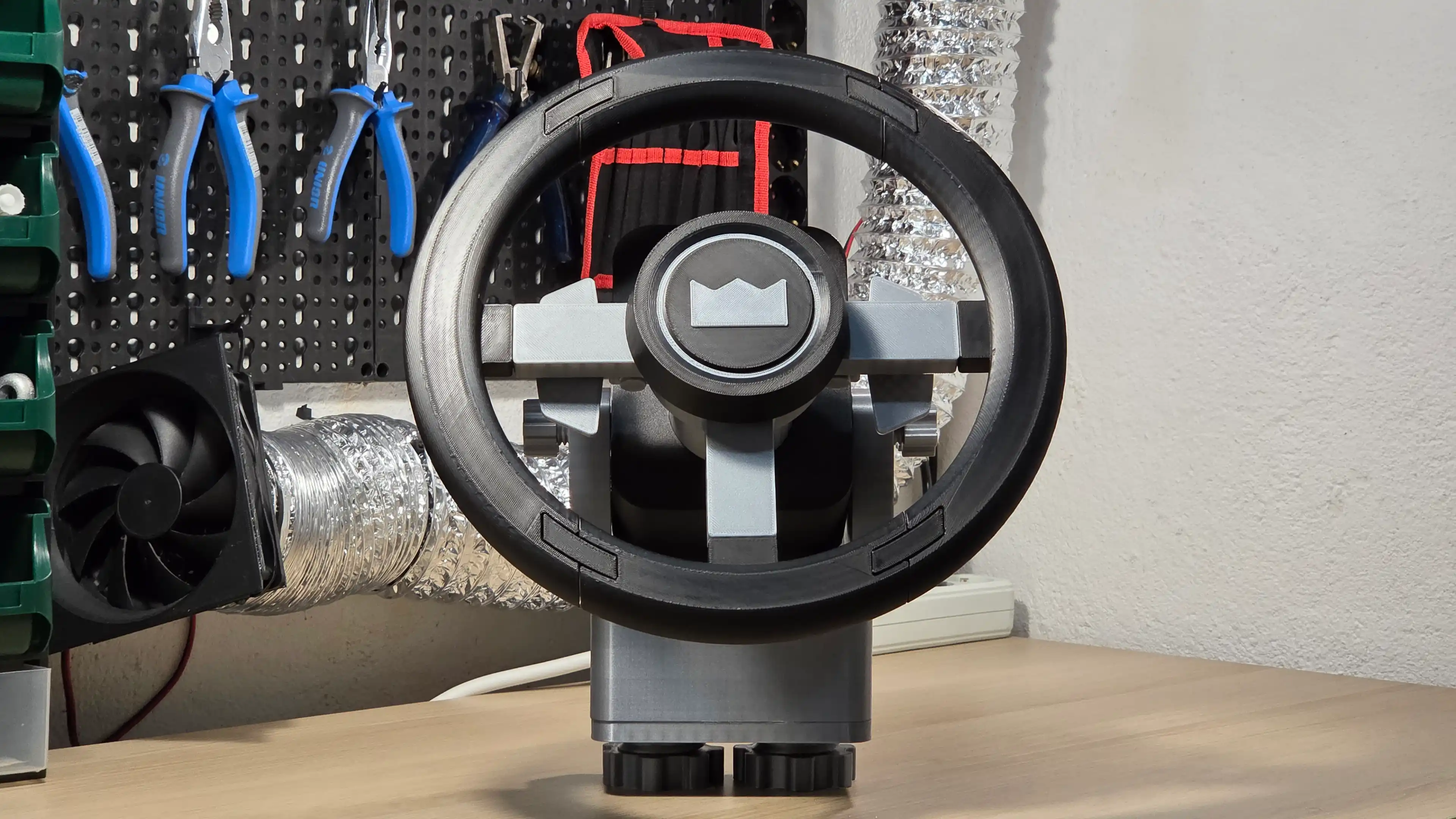 easysteer, the printed steering wheel, seen from the front: black rim, grey spokes and the MandićLab logo on the hub